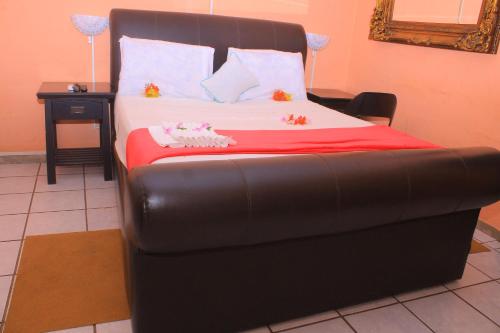 ein Bett mit einem schwarzen Lederbettrahmen in einem Zimmer in der Unterkunft Luma Guest House in Kasane