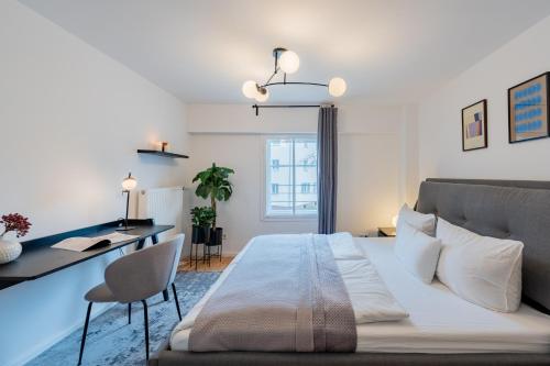 sypialnia z dużym łóżkiem i biurkiem w obiekcie Geräumiges Apartment mit Stadtblick in zentraler Lage Potsdams w Poczdamie