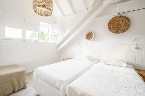 two beds in a bedroom with white walls at Luxe pleine vue mer et plage in Saint-François