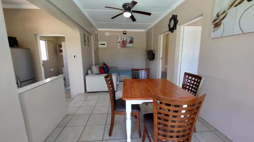 a dining room and living room with a table and chairs at Poolside Guest House in Port Shepstone