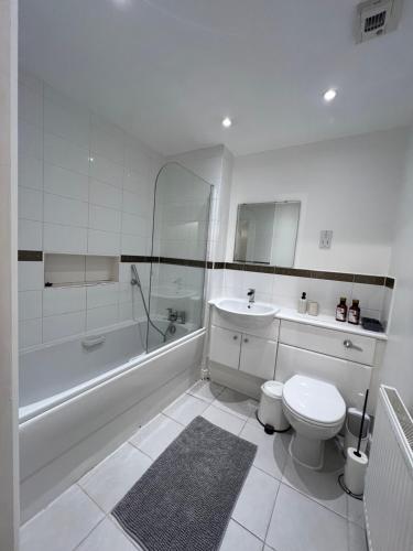 y baño con aseo, bañera y lavamanos. en Centrally Located Flat in London with Free Parking en Edgware