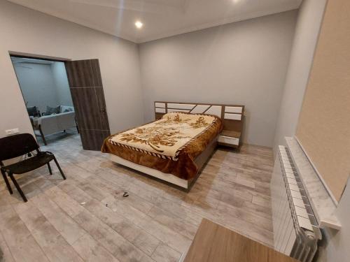 a bedroom with a bed and a chair in it at Lux in Gyumri