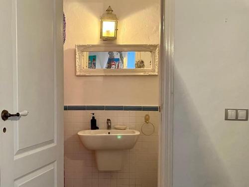 uma casa de banho com um lavatório e um espelho em CASITA LINDA em Facinas