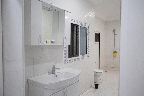 uma casa de banho branca com um lavatório e um WC em VEGAS APERTMENT em Amdalai