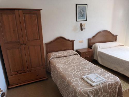 a hotel room with two beds and a dresser at Hostal padornelo in Mondoñedo