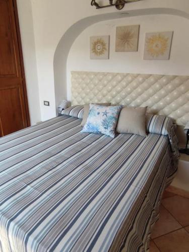 a large bed in a bedroom with a striped mattress at La Casetta in Porto Santo Stefano