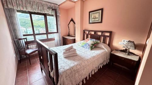1 dormitorio con cama y ventana en Casa Alpargateiro, en Os Peares