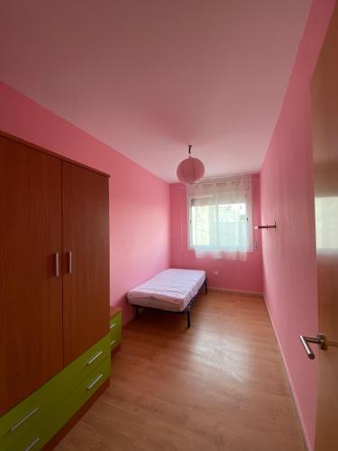 a pink room with a bed and a window at Apartamento Sant Blai in Tivissa