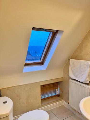 baño con ventana y aseo en Sheil Suites, en Liverpool