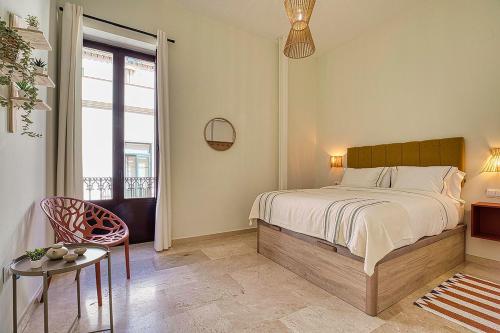 1 dormitorio con cama, mesa y ventana en Suncorner Alameda, en Sevilla