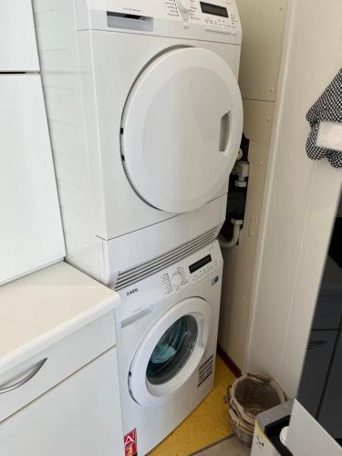 a washing machine and a washer and dryer in a room at Appartement Lijnden in Lijnden