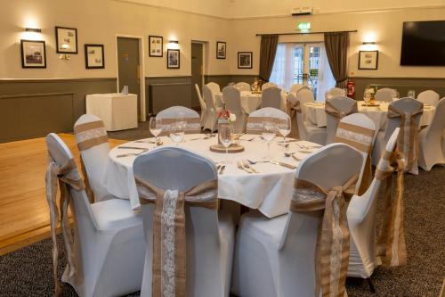 a banquet room with white tables and chairs at Charnwood Arms By Greene King Inns in Coalville