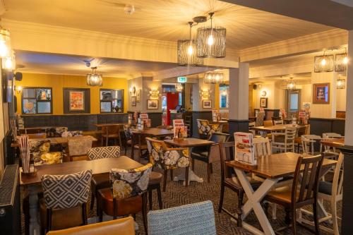 a restaurant with tables and chairs in a room at Charnwood Arms in Coalville