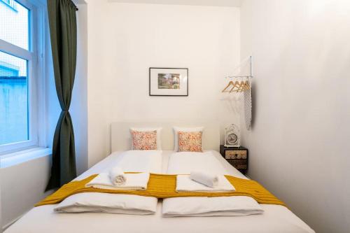 Dormitorio blanco con cama con manta amarilla en HM • Practical 1BR Flat by Center, en Viena