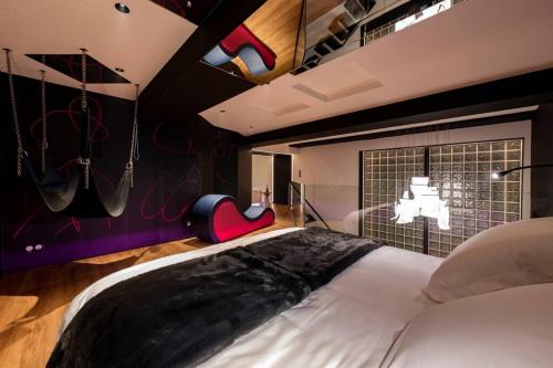 een slaapkamer met een groot wit bed en een raam bij LesSecretsRooms Loveroom -Angers in Angers