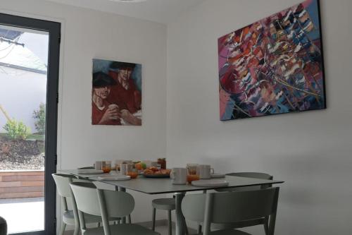 une table de salle à manger avec des chaises et un tableau au mur dans l'établissement Pacharann - Maison de ville 3*- 2 min à pied du port, à La Trinité-sur-Mer