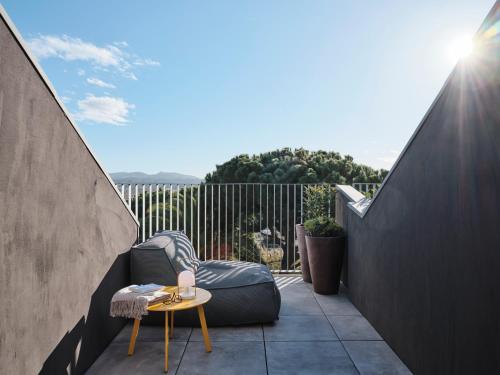 a small patio with a chair and a table at Qgat Restaurant Events & Hotel in Sant Cugat del Vallès