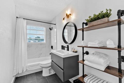 a bathroom with a sink and a toilet and a mirror at Urban Chic Private Pool Home in Hollywood