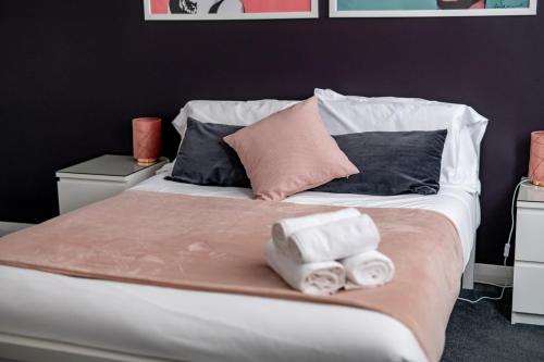 un letto con due asciugamani arrotolati sopra di Brighton Holiday Village PARKING AVAILABLE a Brighton & Hove
