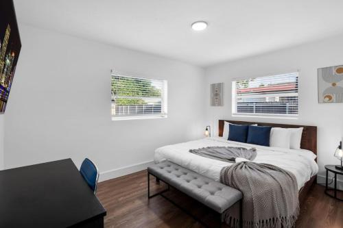 - une chambre blanche avec un grand lit et 2 fenêtres dans l'établissement Tropical Oasis Miami Pool Haven, à Miami Gardens