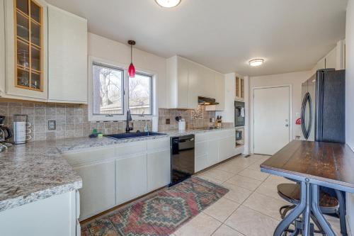 a large kitchen with white cabinets and a table at Eureka Springs Gem 2 Decks, Mtn and Lake Views in Golden