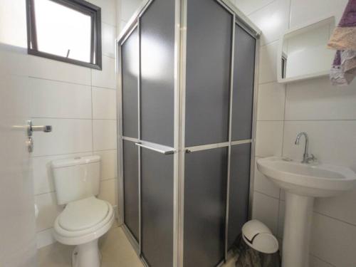 uma casa de banho com um chuveiro, um WC e um lavatório. em Apto Novo Prox. Hosp. Paraná Wi-Fi Fibra - AZ401 em Maringá
