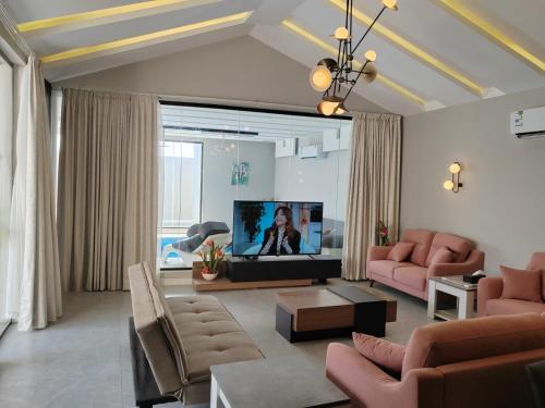 a living room with pink furniture and a flat screen tv at شاليه ومنتجع ملك in Jazan