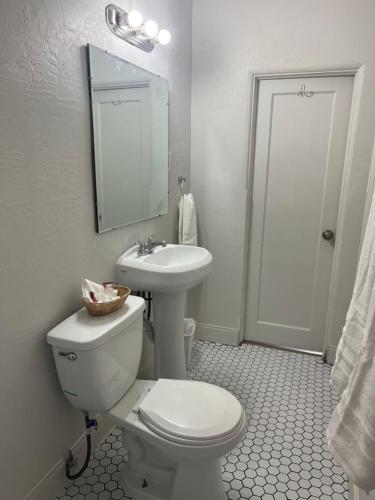 a white bathroom with a toilet and a sink at Arizona 9 Motor Hotel in Williams