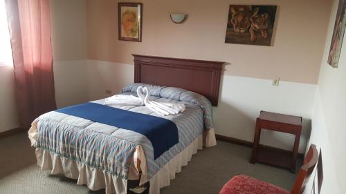 柯塔卡奇的住宿－HOSTERIA RANCHO SANTA FE，一间卧室配有一张白色床 ⁇ 