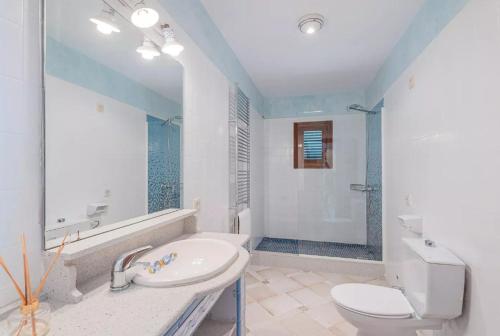 a white bathroom with a sink and a toilet at Es Rafal in Santa Margalida