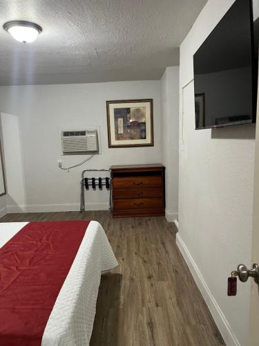 a bedroom with a bed and a flat screen tv at Arizona 9 Motor Hotel in Williams