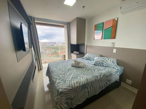 a small bedroom with a bed and a window at Lindo Apartamento dentro do Shopping in Águas Claras