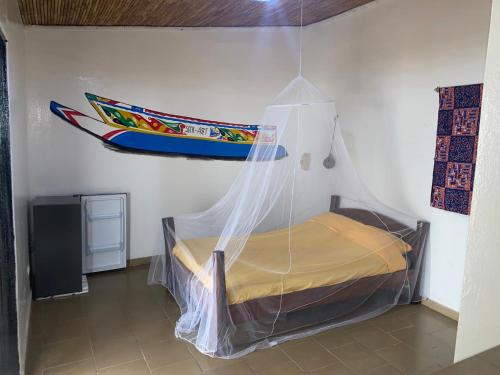 Ngalou SessèneChambre en bord de mer …(pied dans l’eau)的一间卧室,配有一张床,床周围设有蚊帐