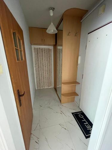 a hallway with a door and a tiled floor at Apartament 11 Stogi in Gdańsk