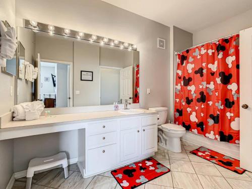 ein Badezimmer mit einem Waschbecken und einem roten Duschvorhang in der Unterkunft Windsor Hills Mickey Mouse Condo, 2.5mi Disney in Orlando