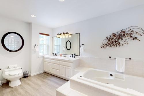 a white bathroom with a tub and a toilet at Blue Skies & Bay Bliss in Carnelian Bay