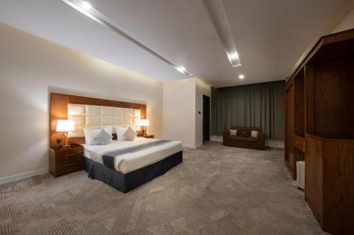 um quarto de hotel com uma cama e um sofá em Diaara Hotel Appartments em Khamis Mushayt