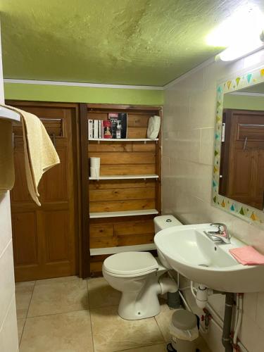 a bathroom with a toilet and a sink at Le Filao 2 in Pointe-Noire