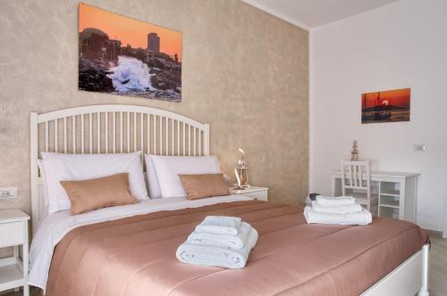 a bedroom with a large bed with towels on it at Vista Mare Rooms in Isola delle Femmine