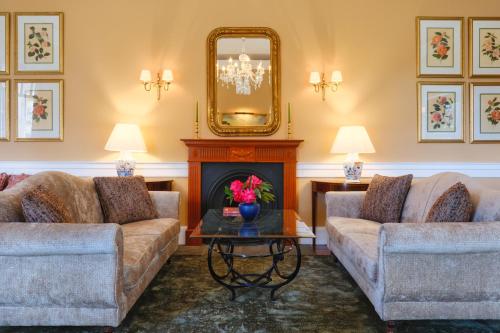 a living room with two couches and a fireplace at Casa Velha do Palheiro Relais & Chateaux in Funchal