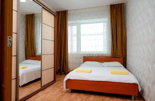 1 dormitorio con 2 camas y espejo en 2 комнатная квартира, по суточно, напротив ТД Сырымбет, en Kokshetau