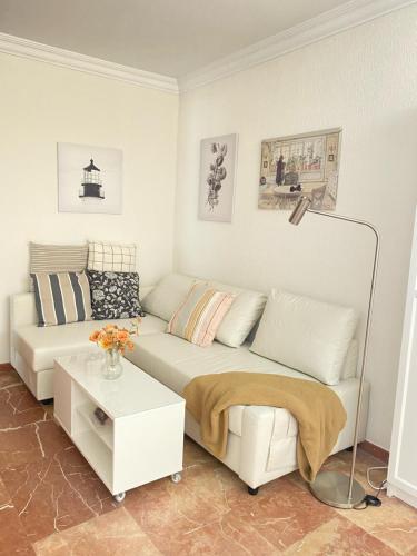 Sala de estar blanca con sofá y mesa en CONCEPCIÓN HOUSE HUELVA, pleno centro, GARAJE en el propio edificio en Huelva