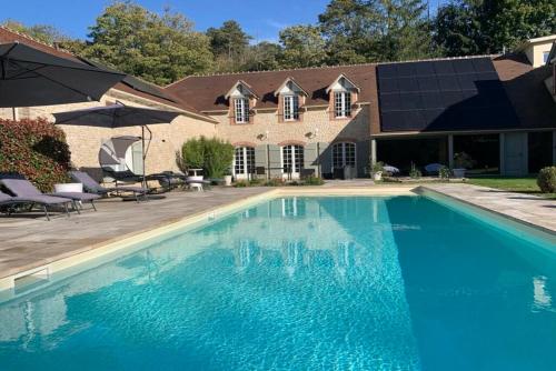 a swimming pool in front of a house at Domaine des rives d'Ormoy - Athamante in Ormoy-la-Rivière