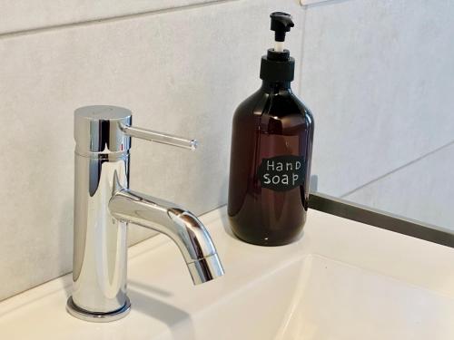 イーゾラ・ロッサにあるL'Approdo Apartmentsの洗面台の横に置いたボトル入りヘアソープ