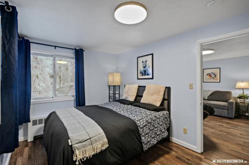a bedroom with a bed and a window and a couch at White Raven Perch Westwood 6 in Anchorage