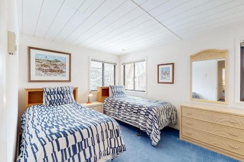 a bedroom with two beds and a dresser and windows at Creekside 1274 in Sun Valley