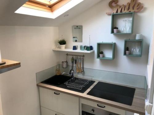 une cuisine avec un évier et un plan de travail dans l'établissement Maison quartier plage refaite à neuf, à Fécamp