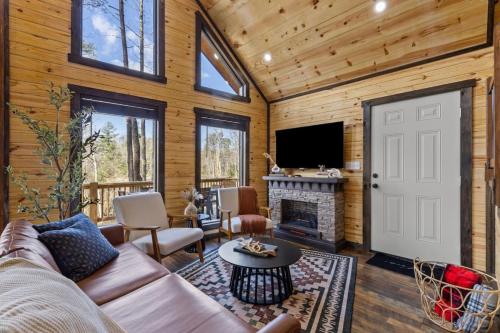 a living room with a couch and a fireplace at Private Cabin w King Bed and Private Hot Tub in Rogers