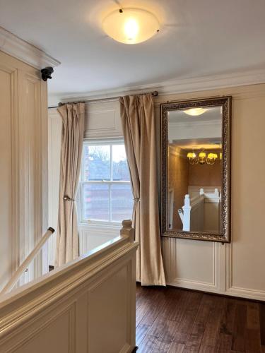 un pasillo con un espejo en la pared junto a una ventana en The Mountford Hotel - Free Parking en Liverpool