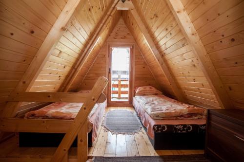 NiegowaにあるDomki Niegowaの木造キャビン内のベッドルーム1室(ベッド2台付)
